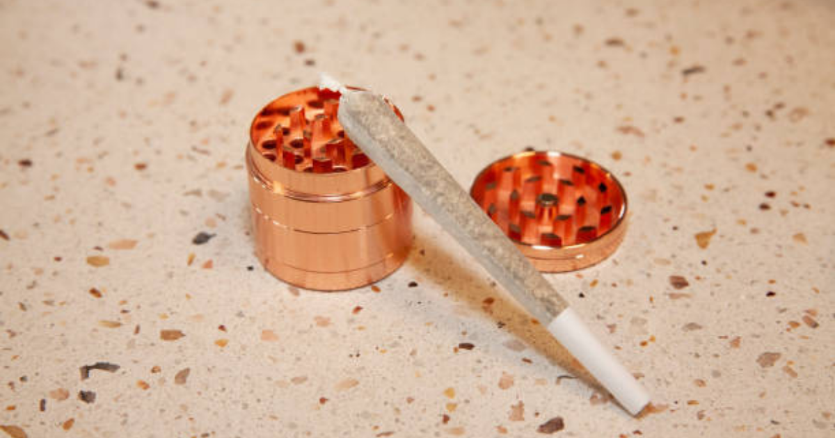 A tightly packed pre-roll cone beside tools like a tamping stick and toothpick, ready for airflow adjustment.