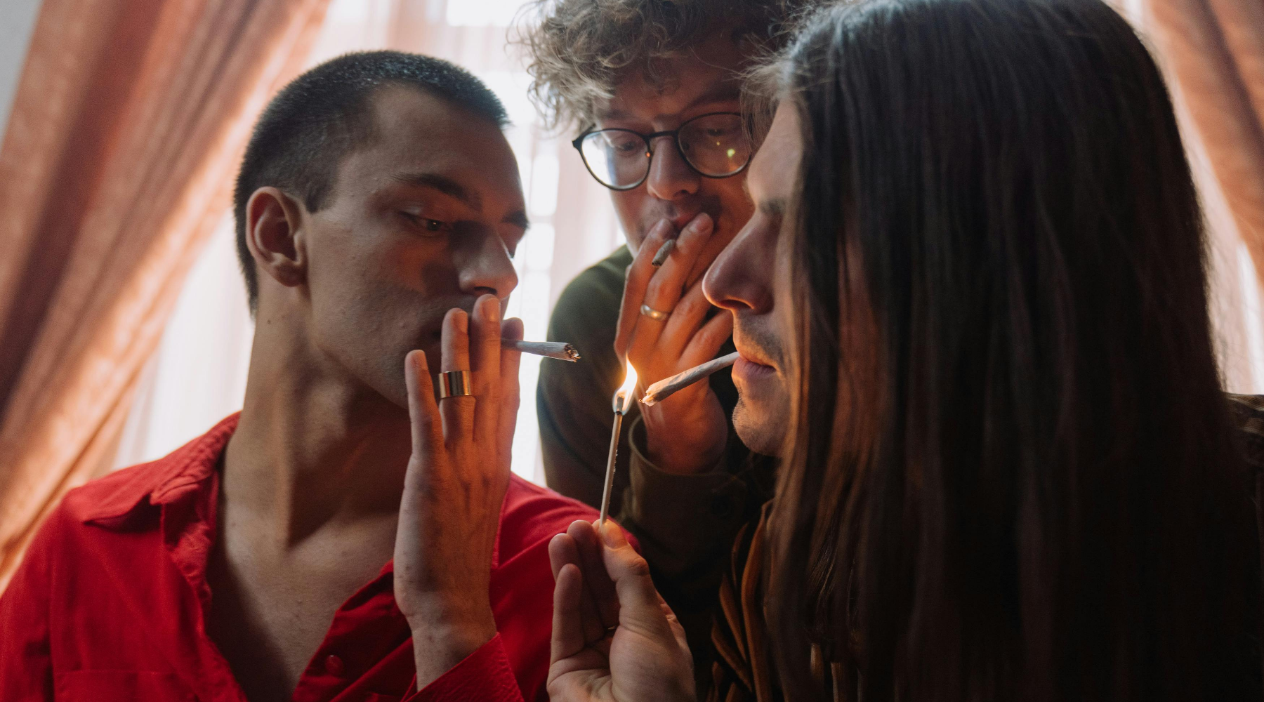 Close-up of people smoking a blunt with tobacco-free wrap they used in joint rolling.