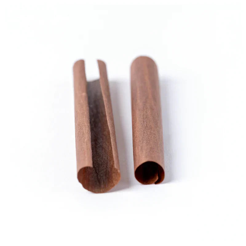 Two brown tobacco free blunt wraps for pre rolls displayed on top of a white floor and in front of a white background.
